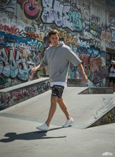 Model walking while wearing All-Over Print Unisex Athletic Long Shorts
